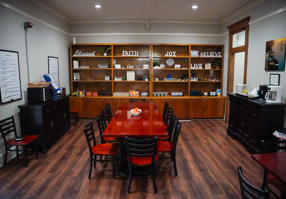 There is a large table and chairs in the middle of the room.