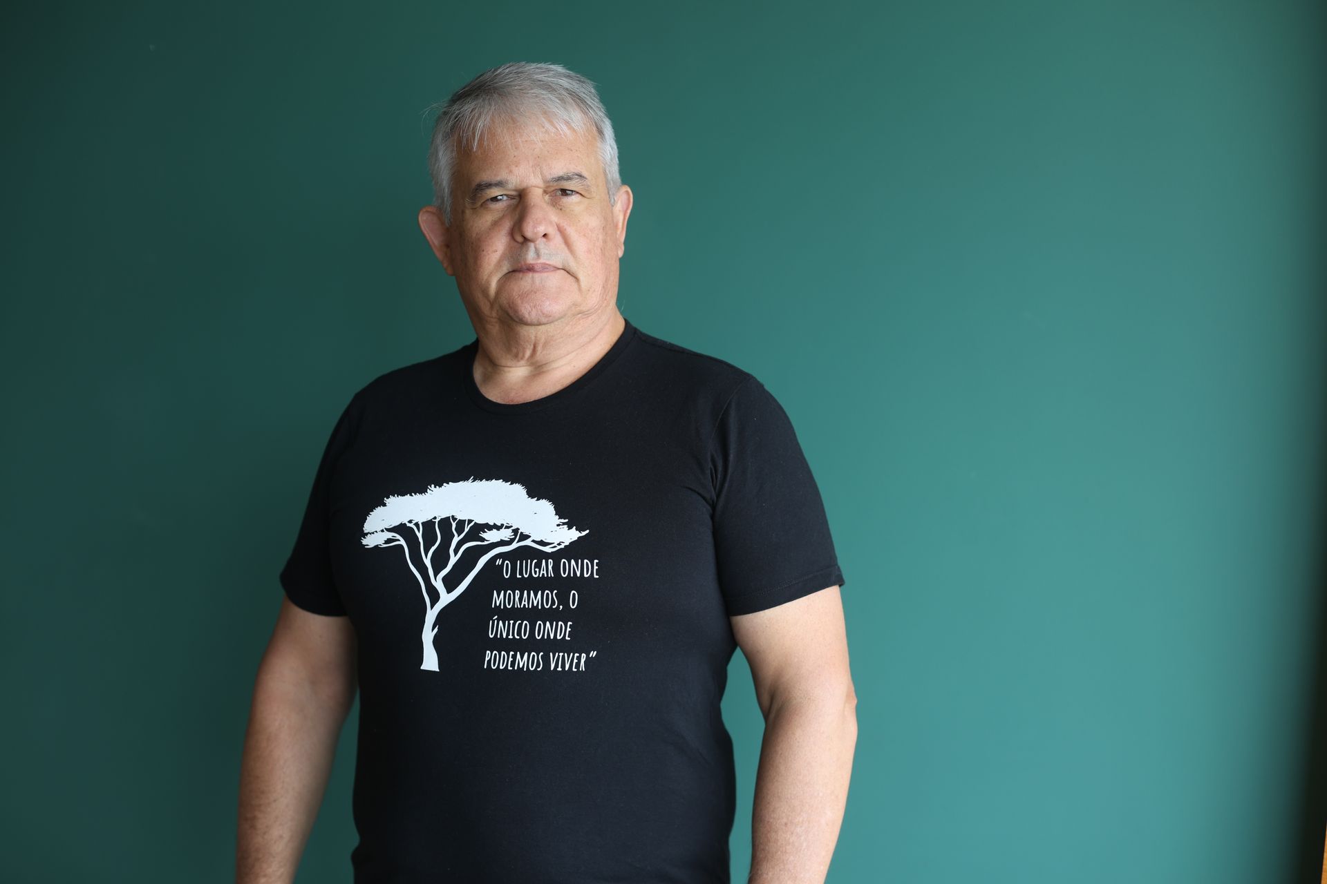 Fábio Sartori, vestindo uma camiseta preta com uma árvore branca estampada.