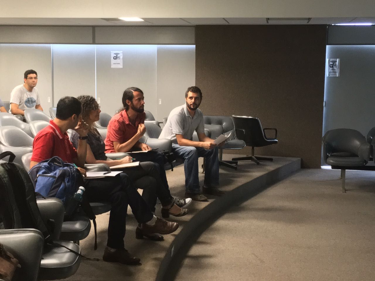 Um grupo de pessoas está sentado em uma sala de aula
