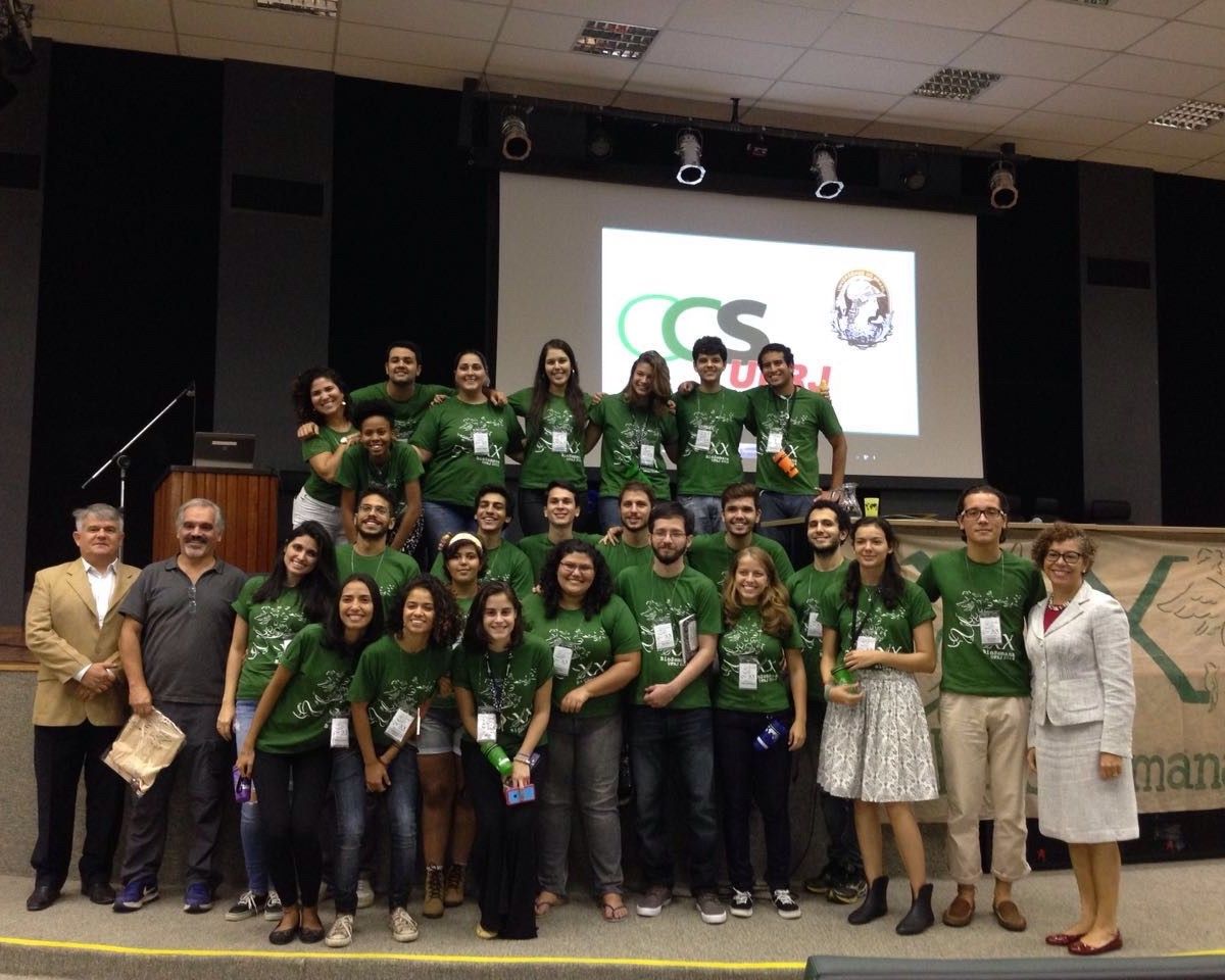 Um grupo de pessoas posando para uma foto em frente a uma tela que diz cs