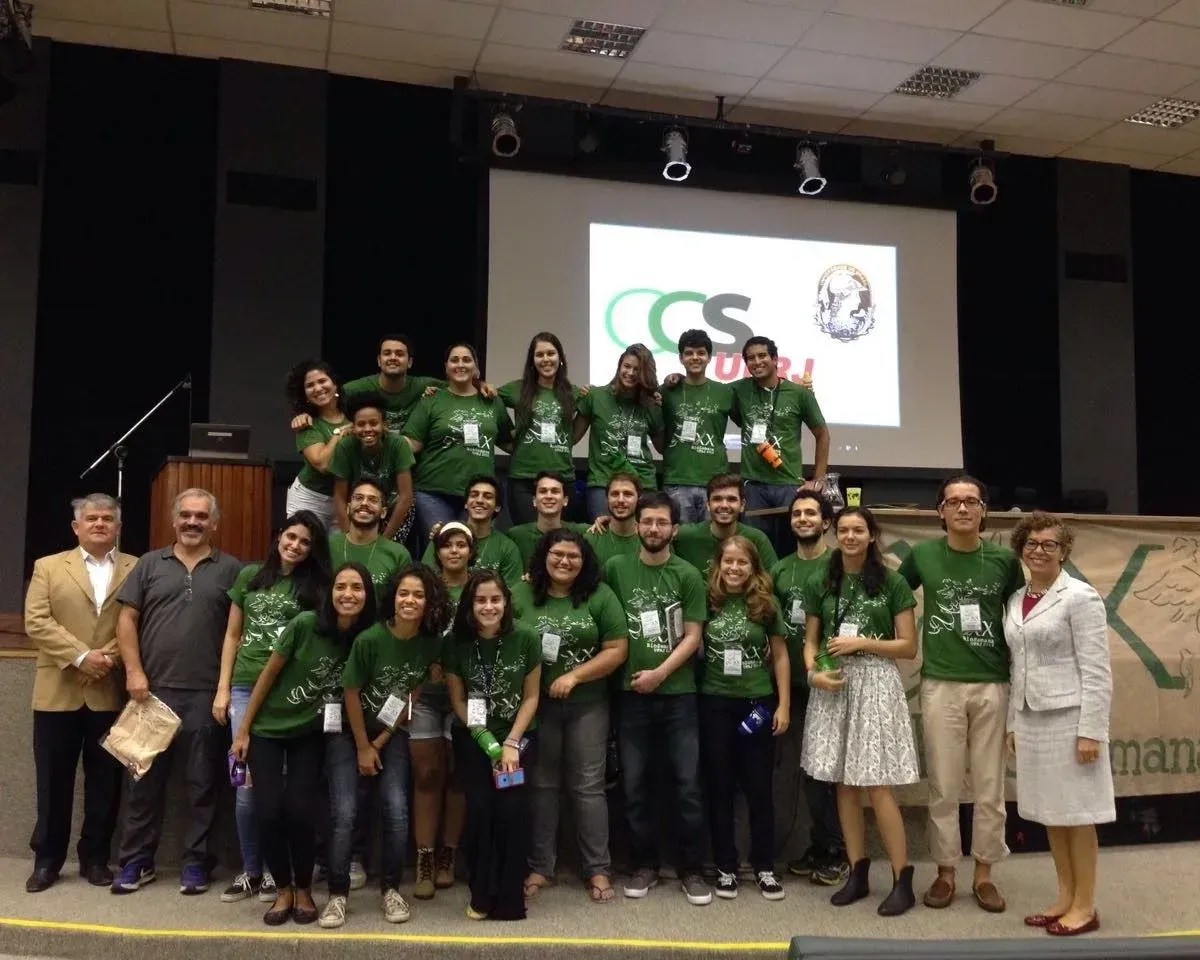 Um grupo de pessoas posando para uma foto em frente a uma tela que diz cs