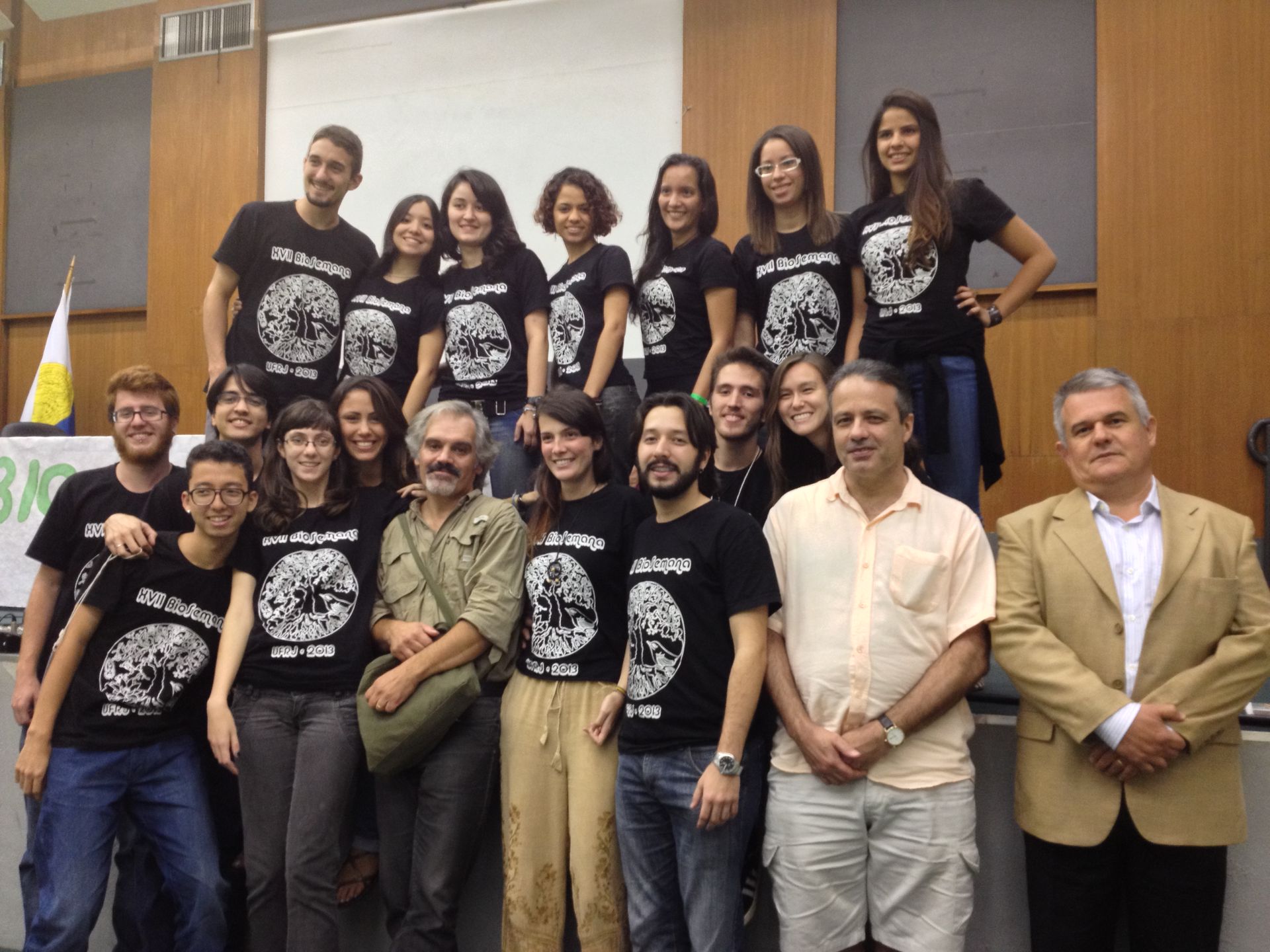 Um grupo de pessoas posando para uma foto com um homem vestindo uma camisa de caveira