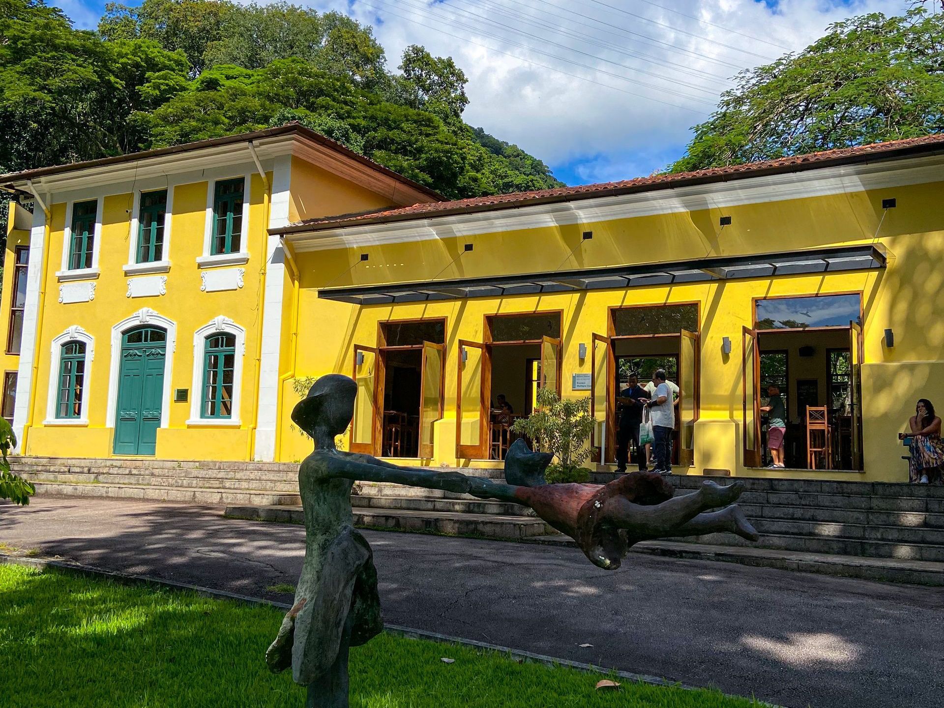 Um prédio amarelo com uma estátua na frente