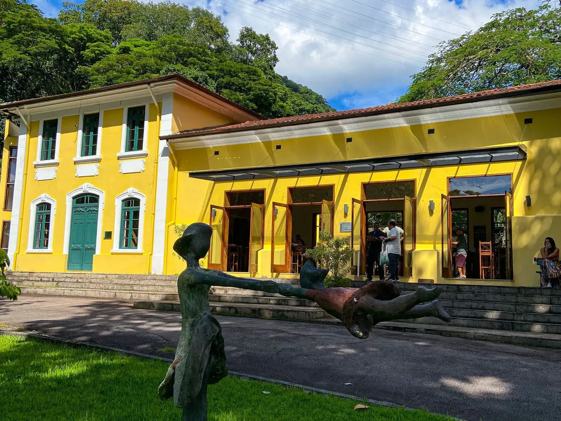 Um prédio amarelo com uma estátua na frente