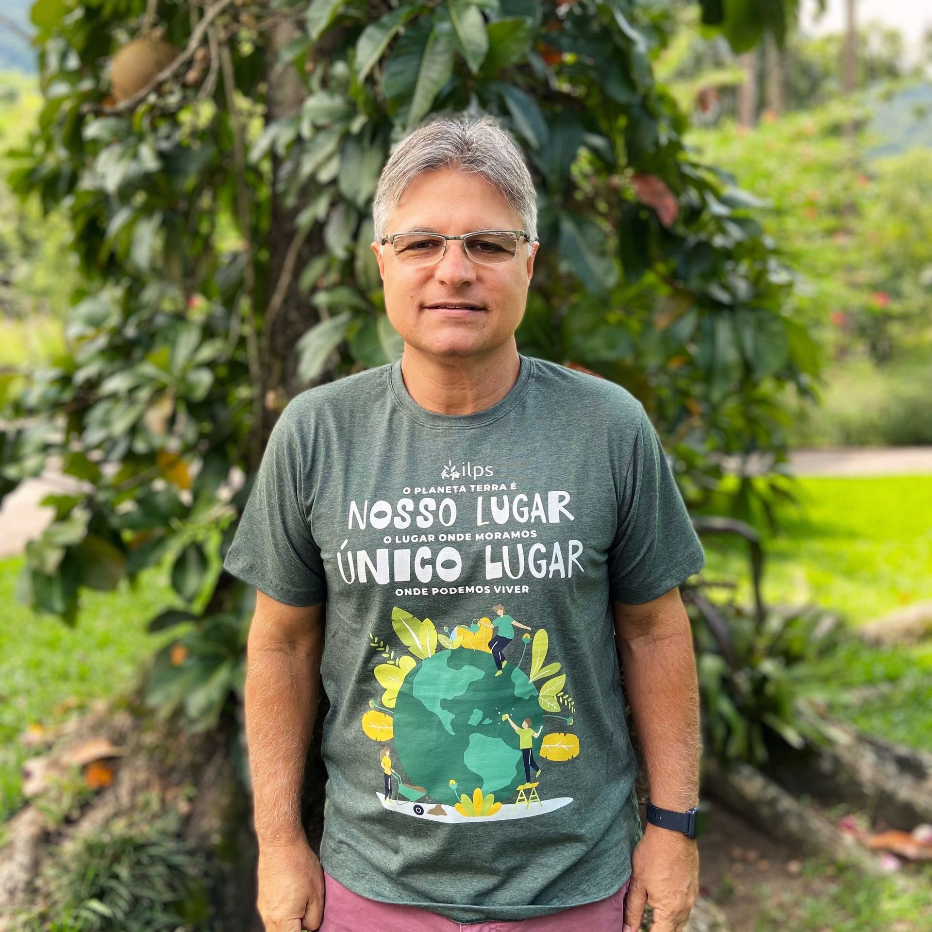 A man wearing a t-shirt that says nosso lugar unico lugar