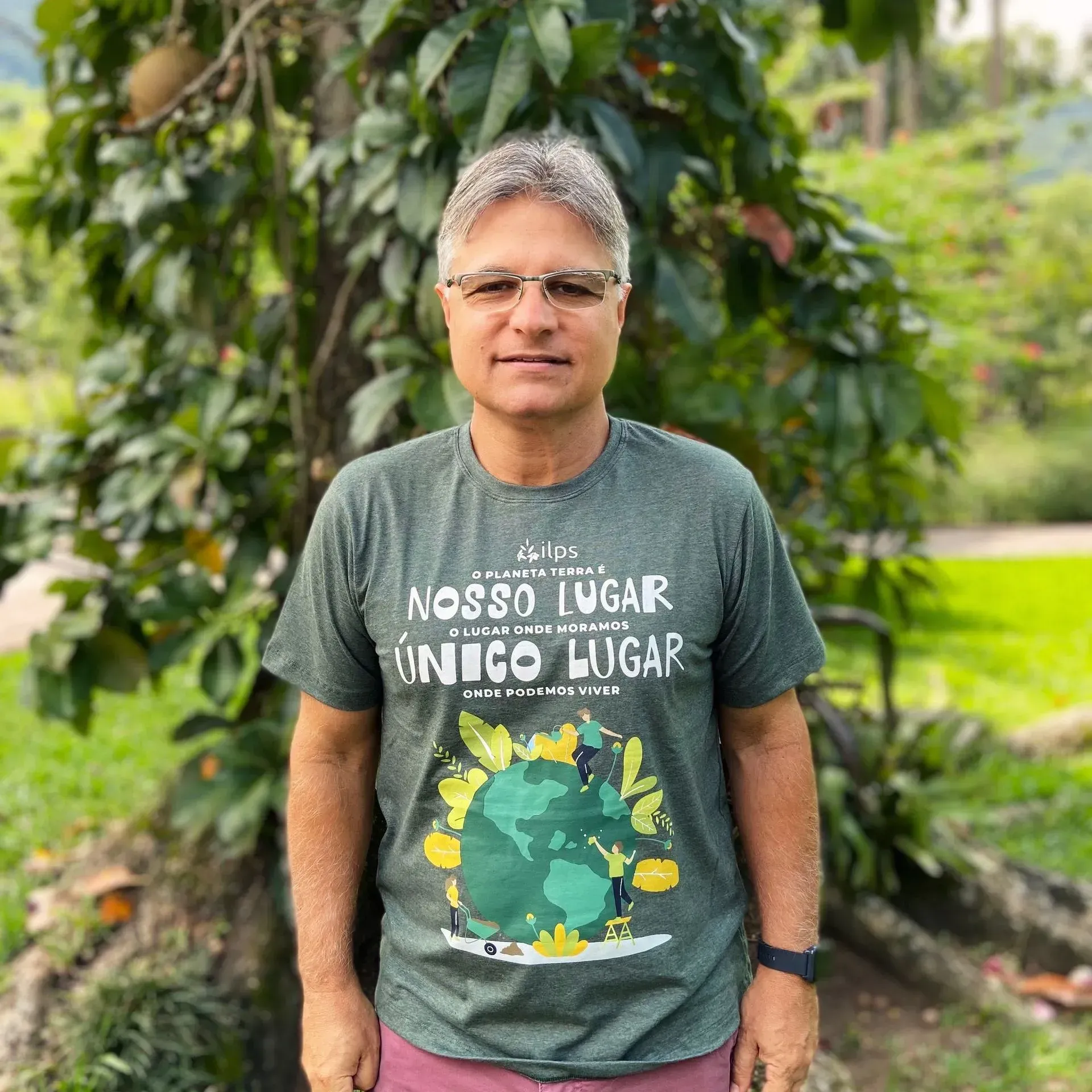 A man wearing a t-shirt that says nosso lugar unico lugar