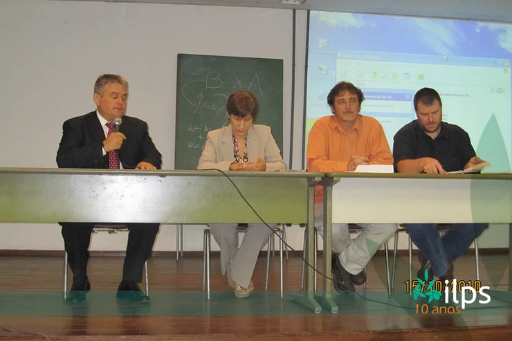 Um grupo de pessoas sentadas em uma mesa com ips escritos na parte inferior