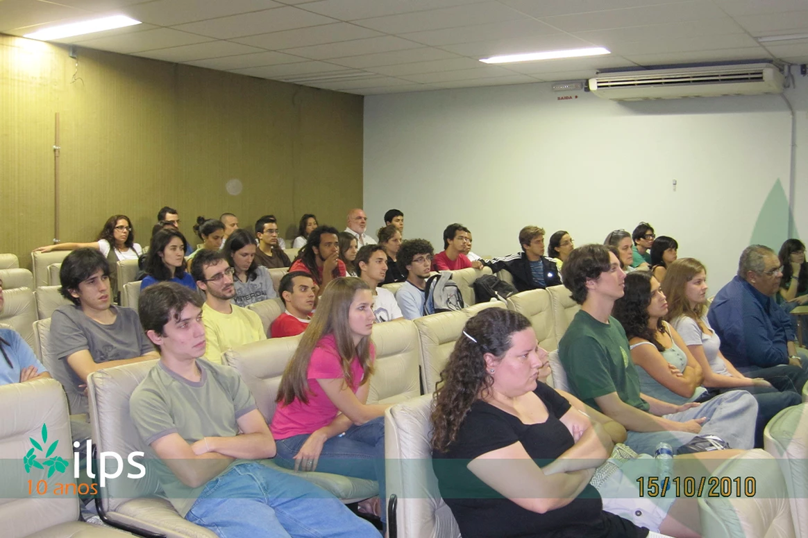 Um grande grupo de pessoas está sentado em uma sala de aula.