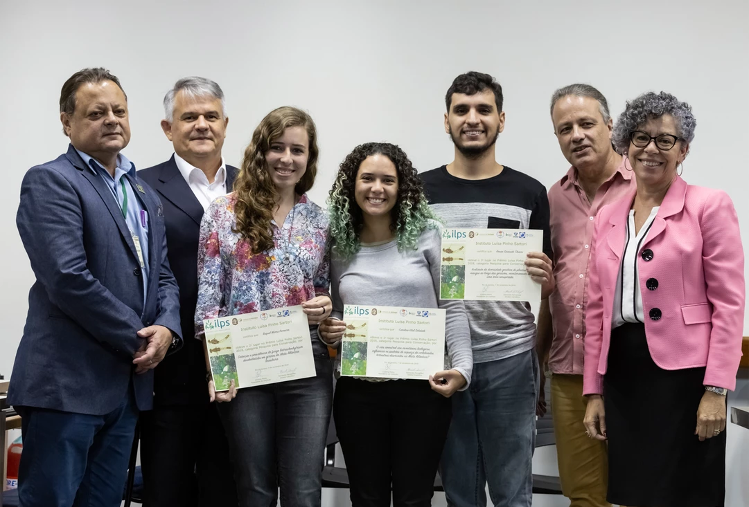 Um grupo de pessoas próximas umas das outras segurando certificados.