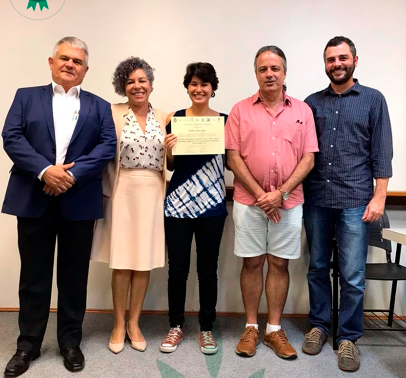 Um grupo de pessoas posando para uma foto com uma mulher segurando um certificado