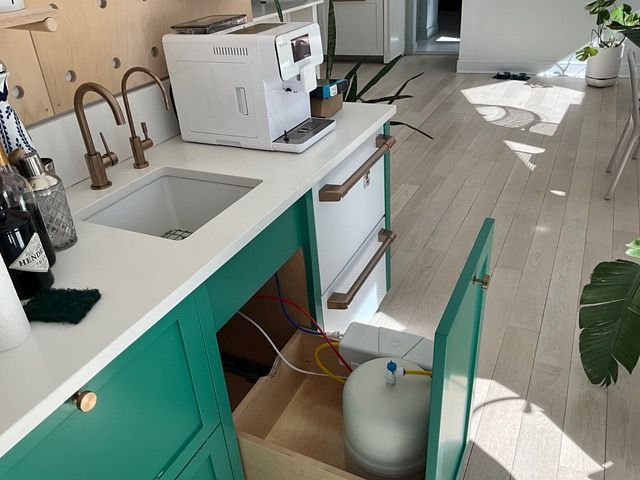 A kitchen with green cabinets and a white coffee maker