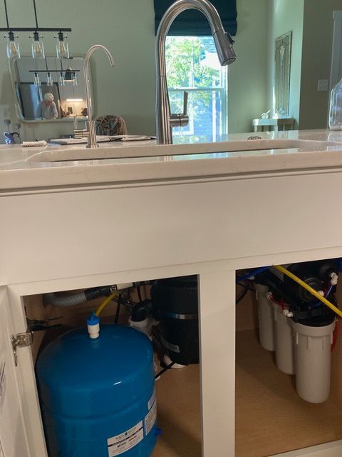 A kitchen sink with a blue tank underneath it