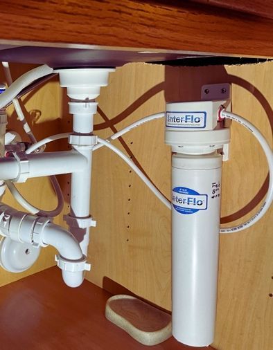 A kitchen sink with a water filter attached to it