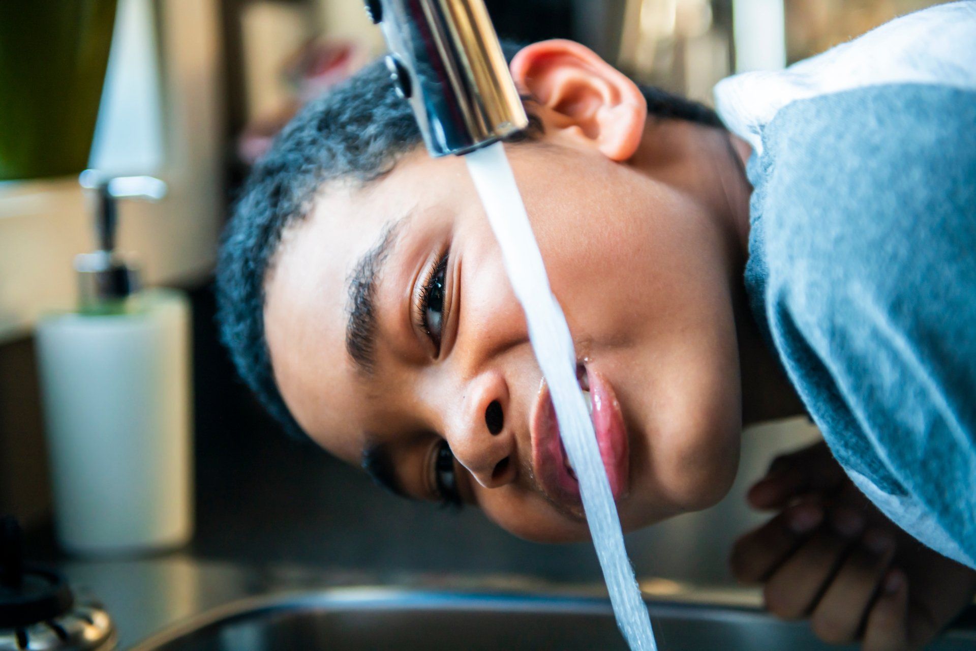 Boy take water on his mouth