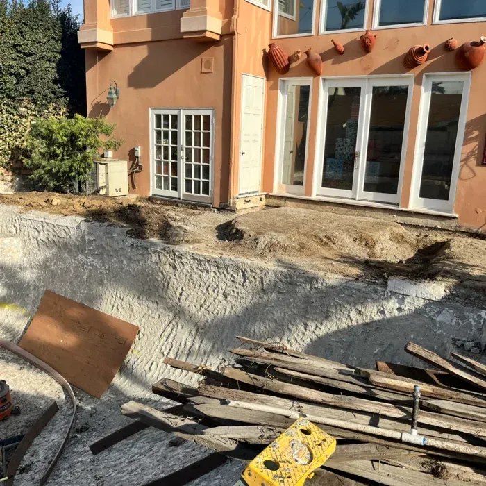 House exterior with a large excavated yard and scattered construction materials