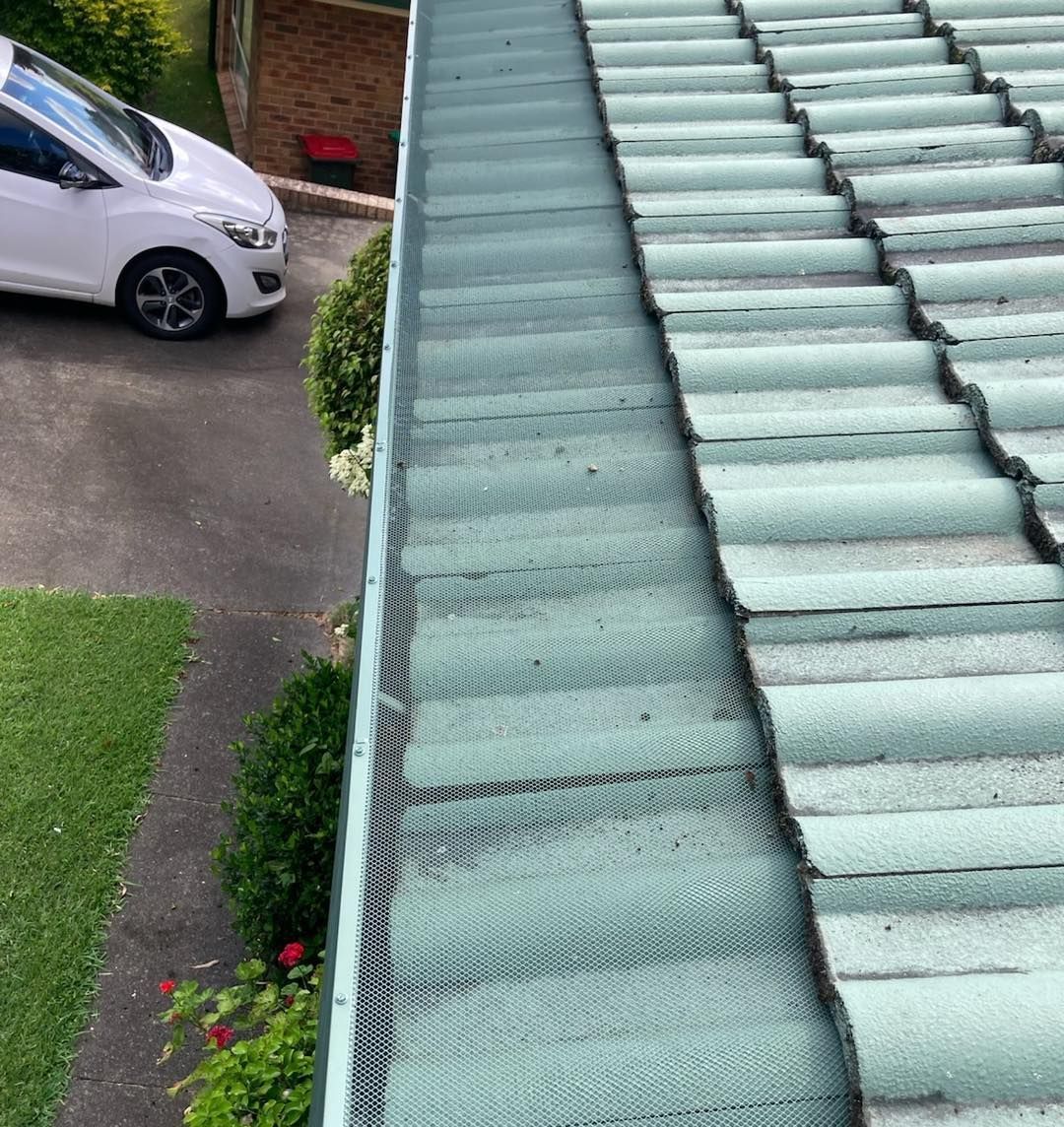A white car is parked on the side of a roof next to a gutter. — Wayne Treasure Roofing & Restoration In Nabiac, NSW