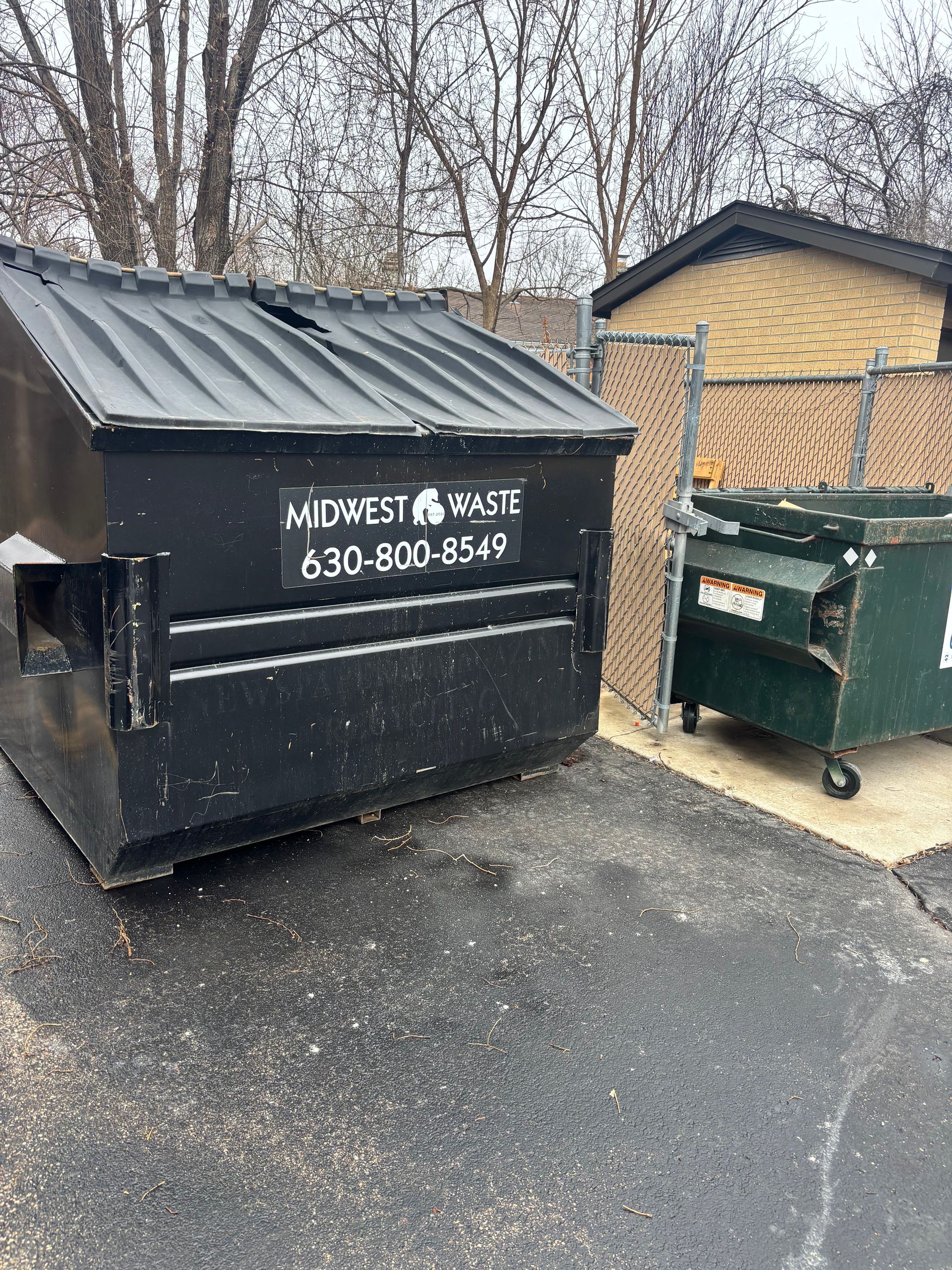 A large black dumpster labeled 