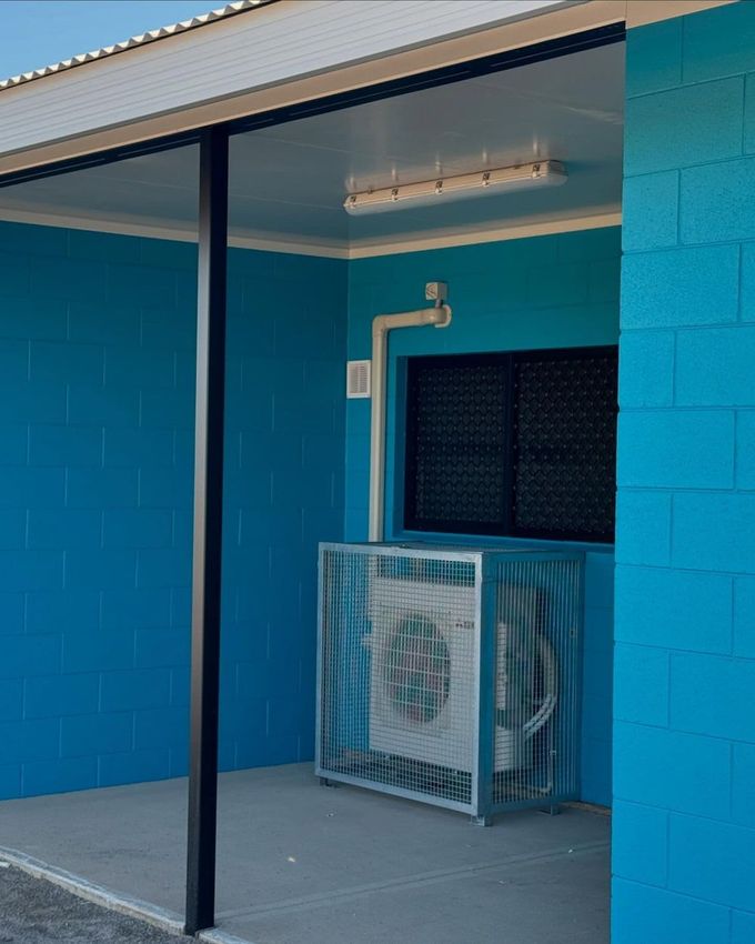 Blue Building With a Fan on the Side of It — AJ Services in Alice Springs, NT