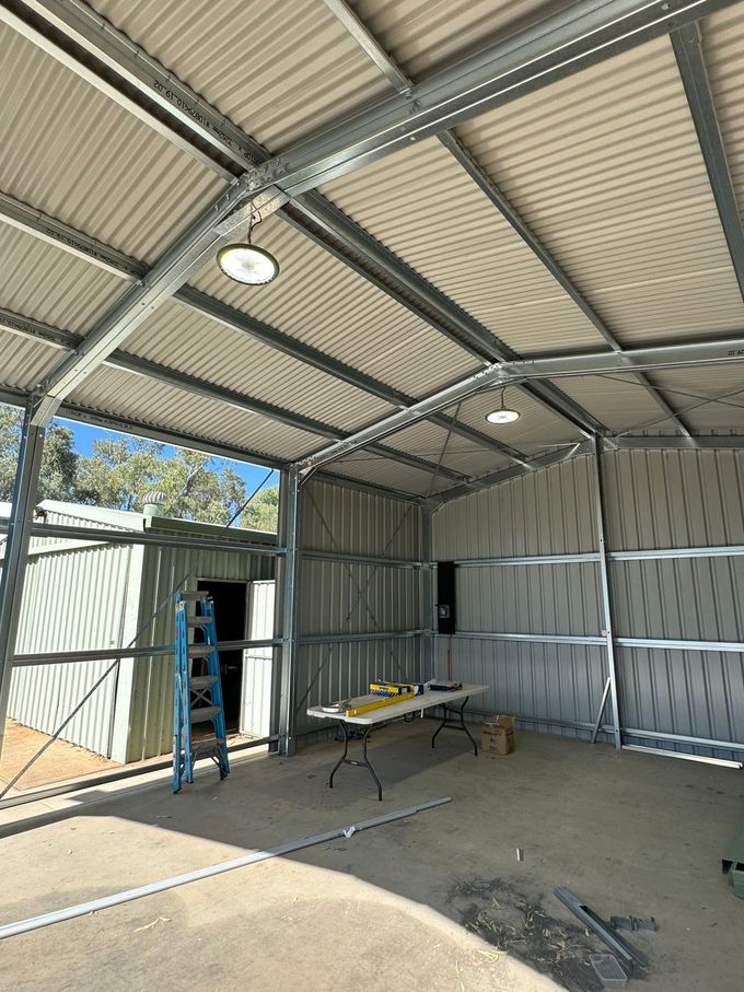 The inside of a metal building with a table and ladder  — AJ Services in Alice Springs, NT