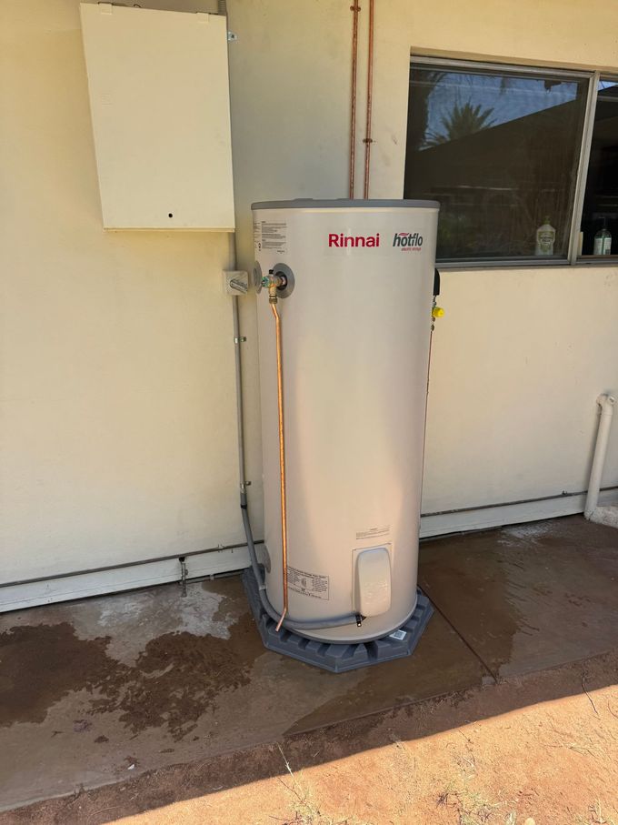 A white water heater is sitting on the side of a building — AJ Services in Alice Springs, NT