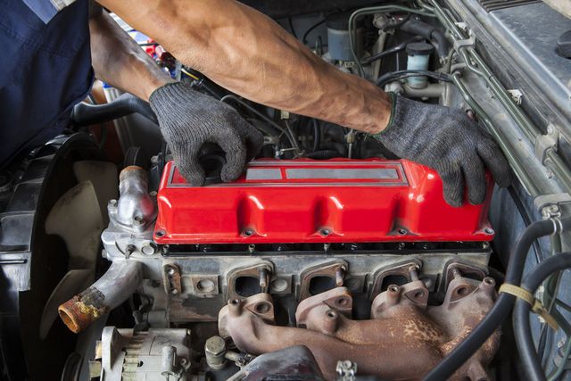 A man is working on the engine of a car.