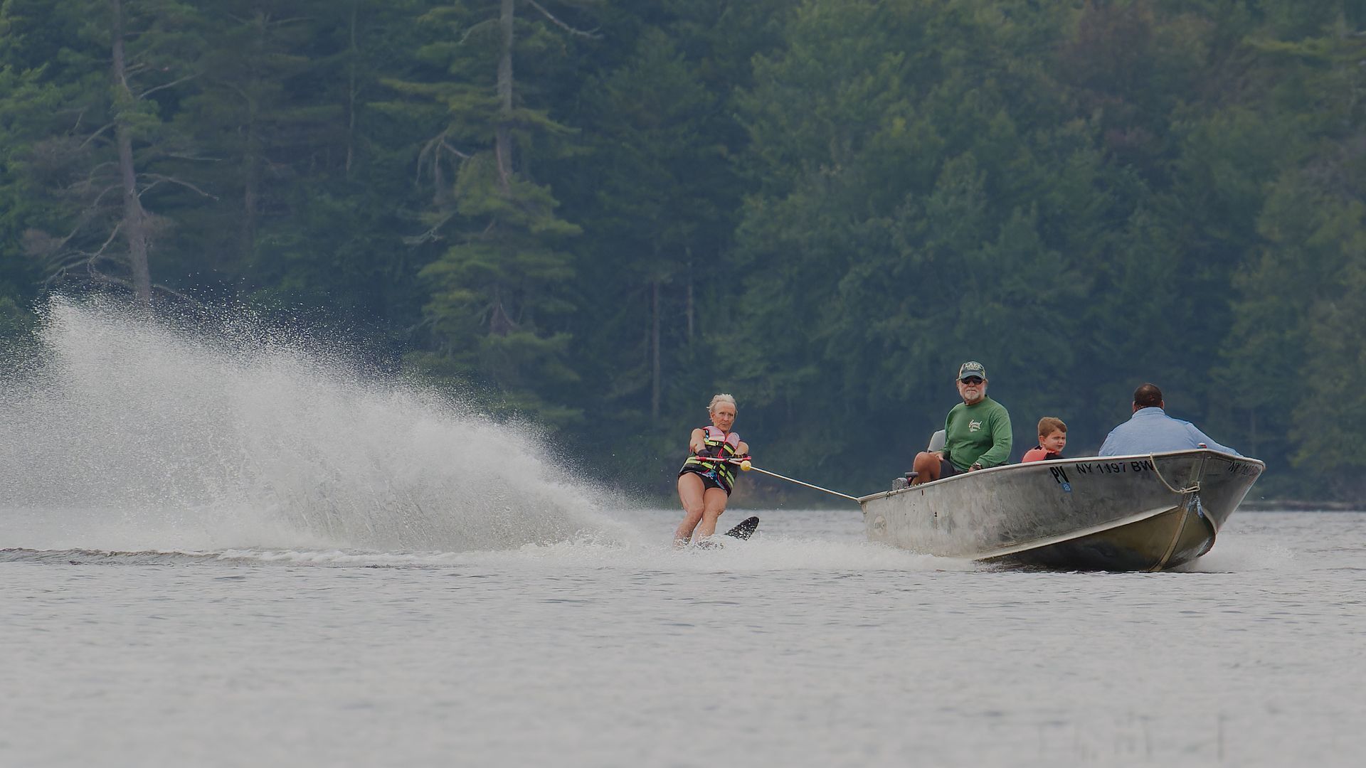 a woman is being towed by a boat on a lake .