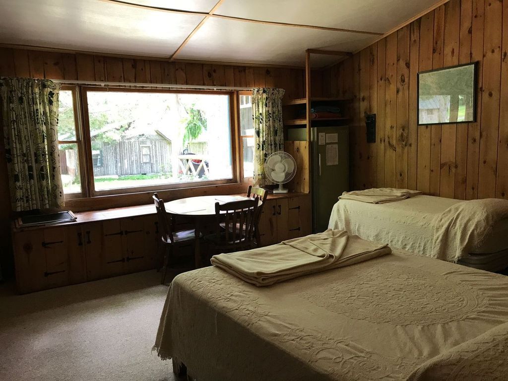 a bedroom with two beds , a desk and a window .