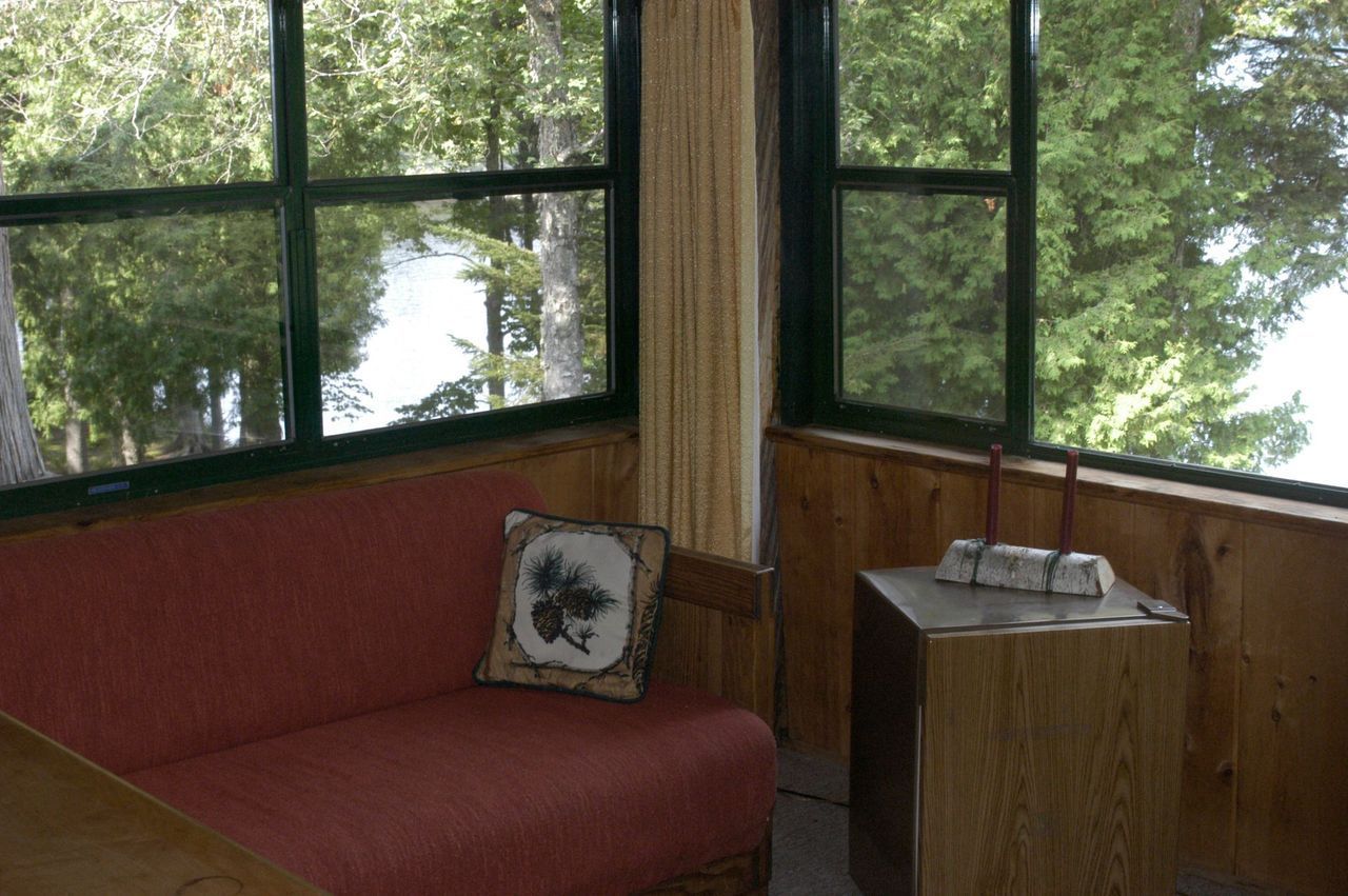 a living room with a red couch and a large window