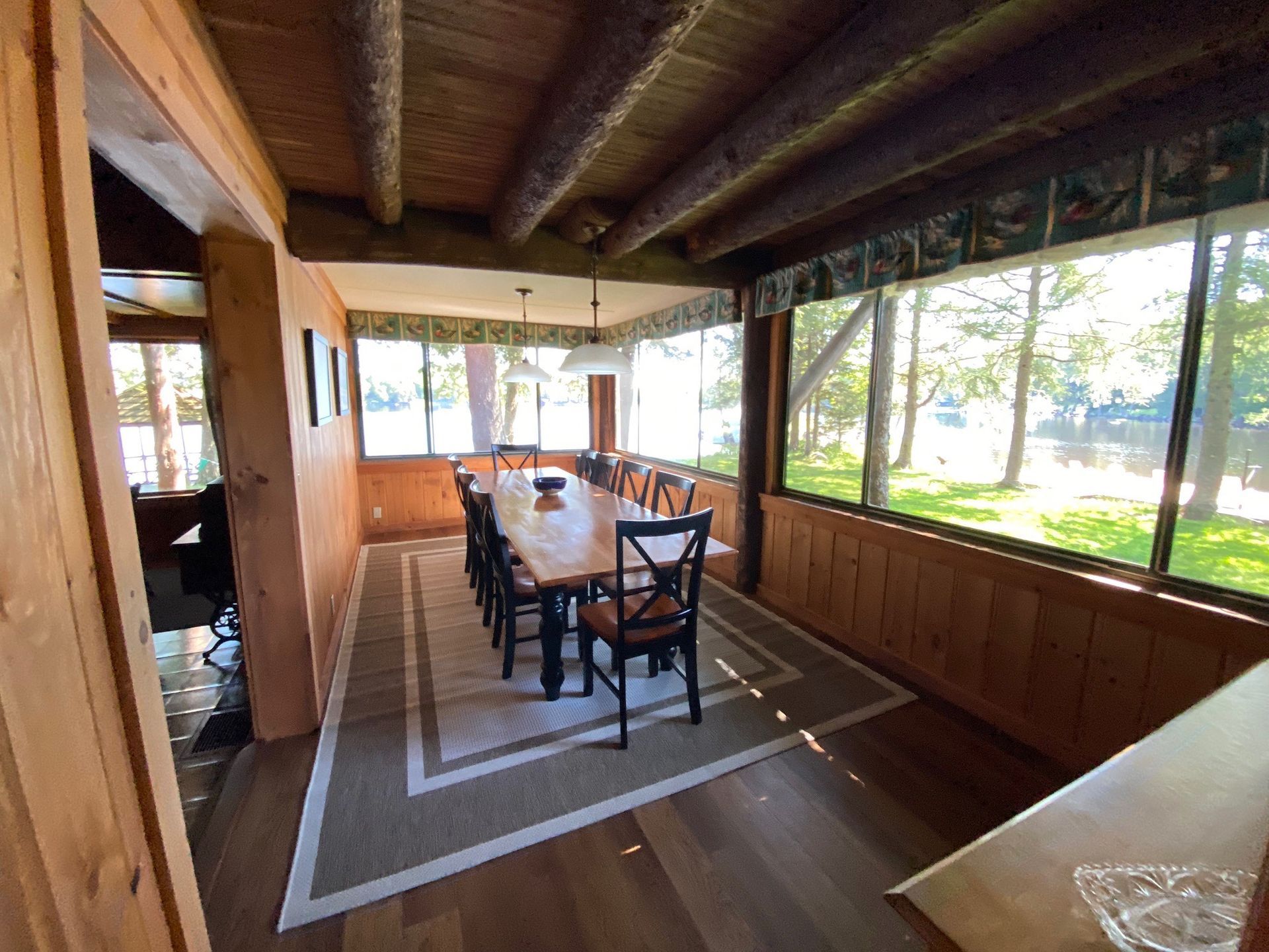 a dining room with a long table and chairs and a lot of windows .