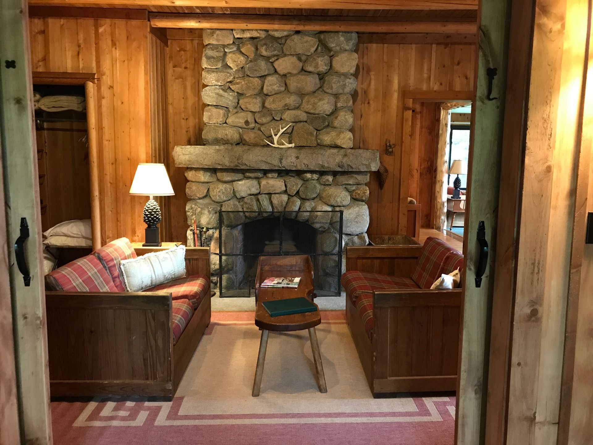 a living room with a stone fireplace and two couches .