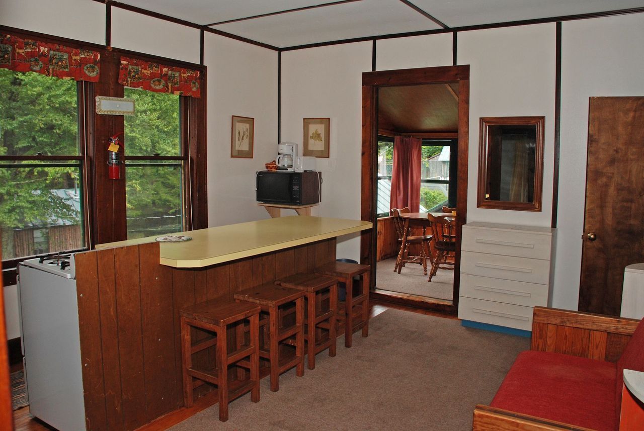 a living room with a bar and stools in it