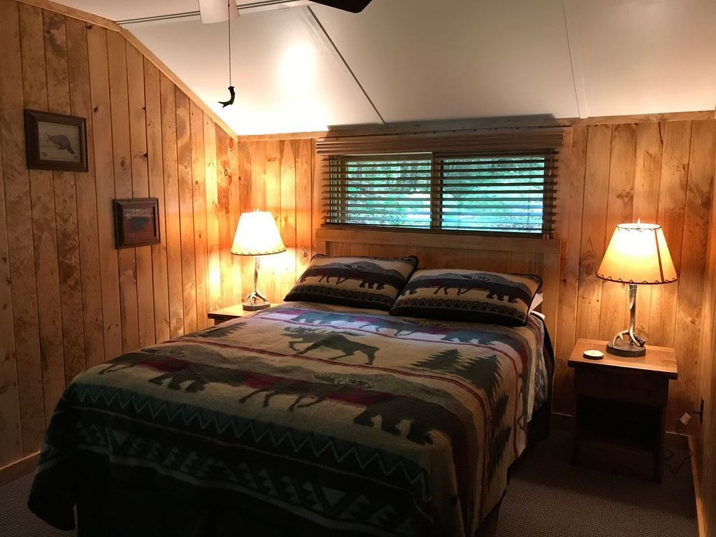 a bedroom with a bed , two lamps and a window