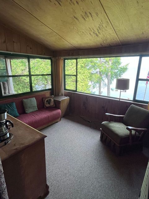 a living room with a couch and a chair and a large window .