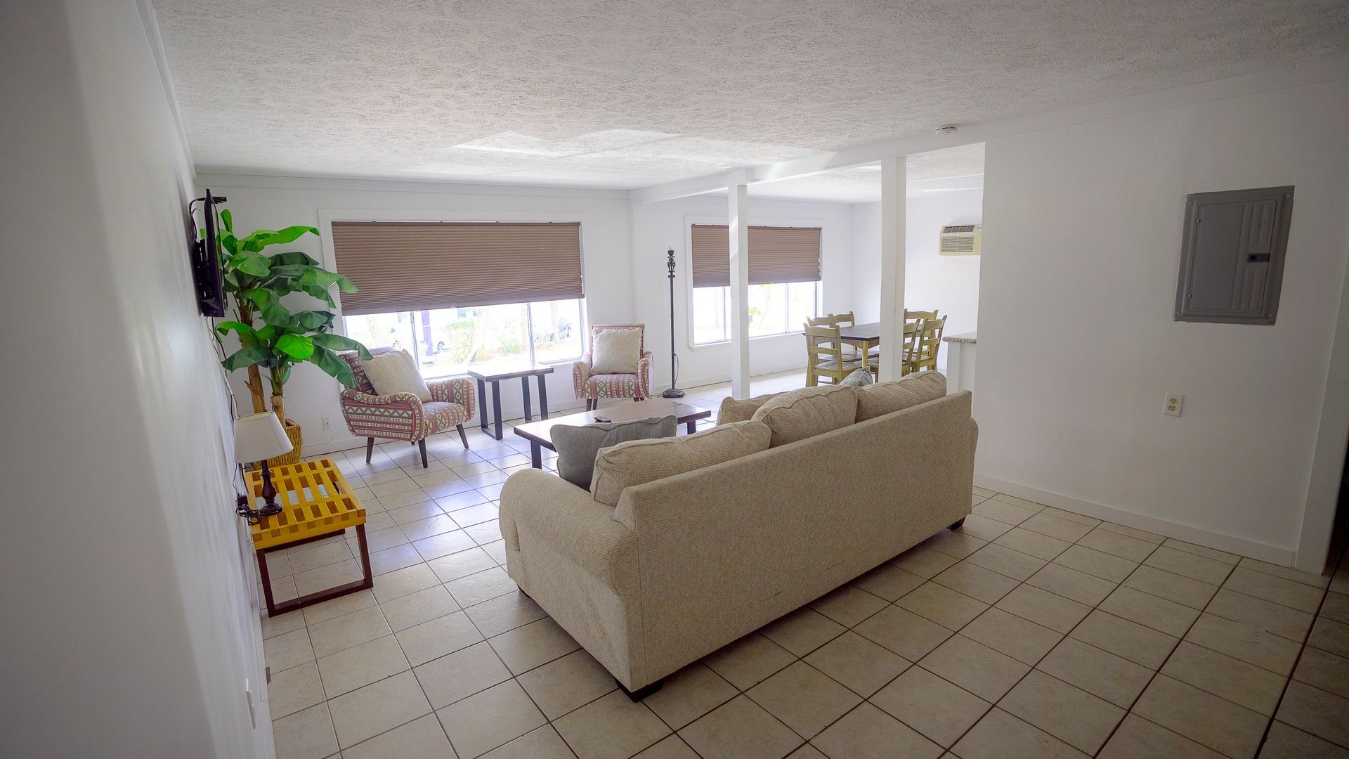 A living room with a couch , chairs , and a table.