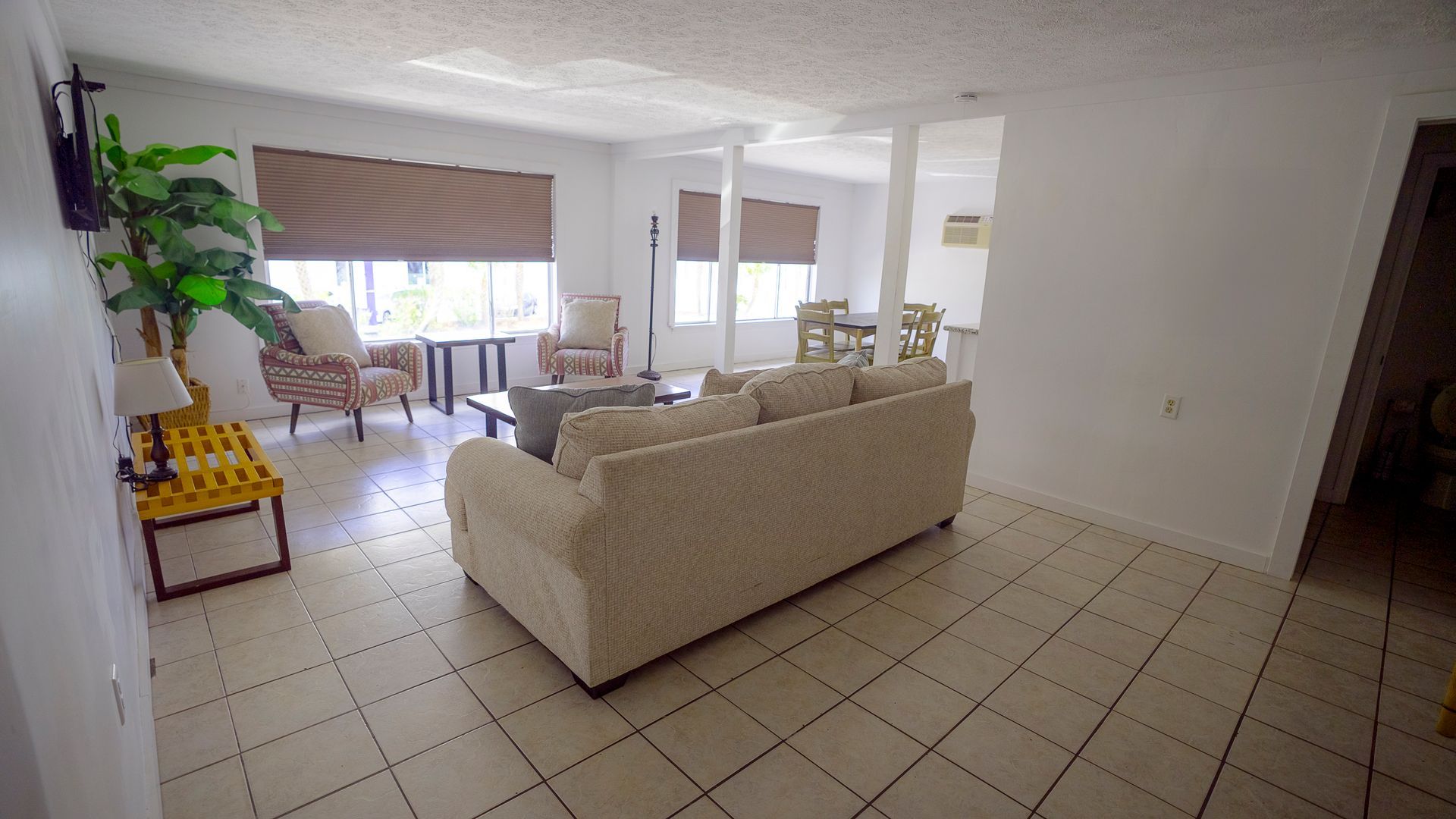 A living room with a couch , chairs , and a table.