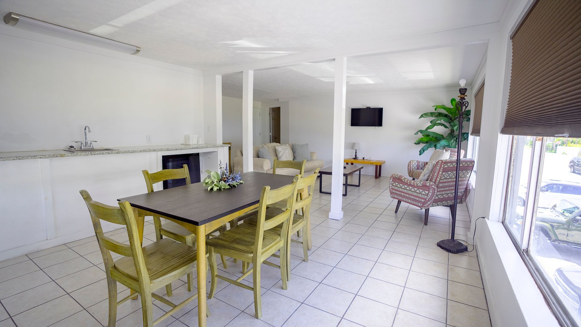 There is a table and chairs in the middle of the room.