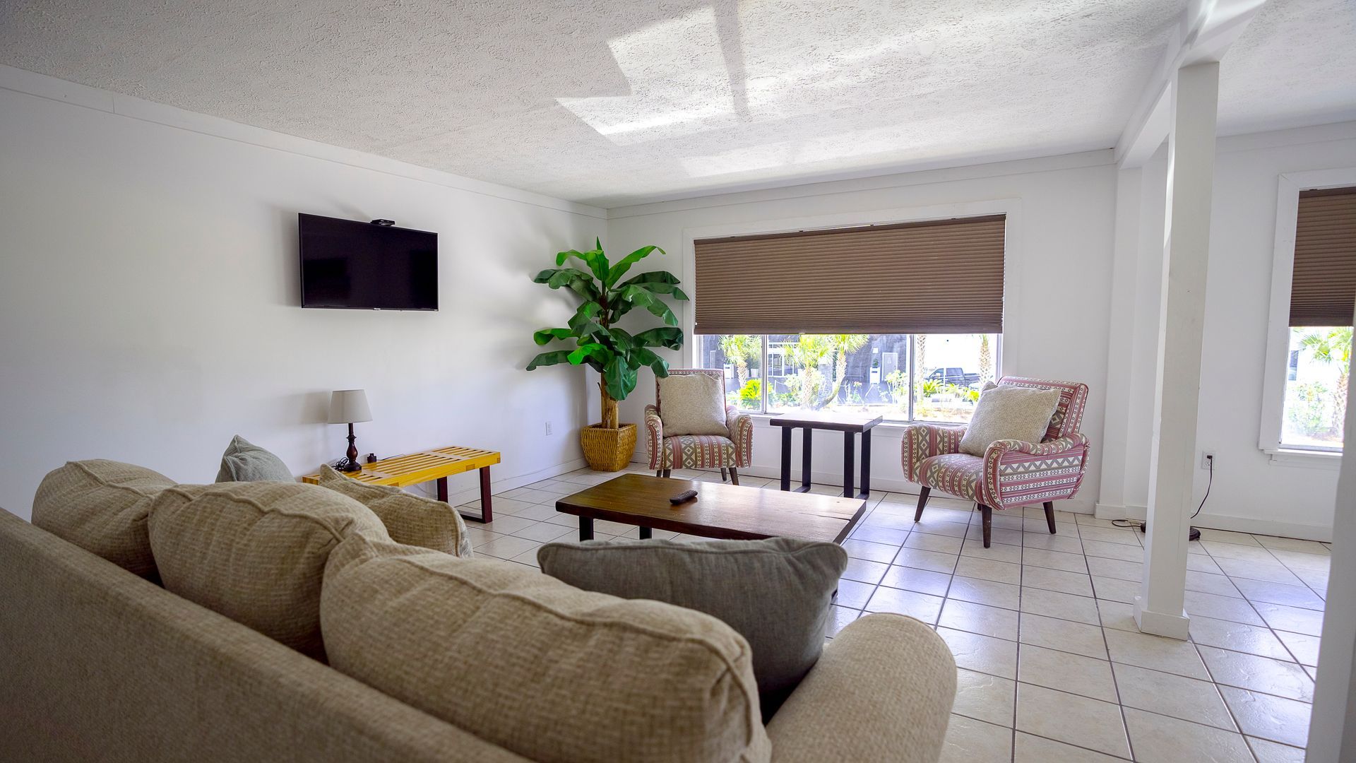 A living room with a couch and chairs and a flat screen tv