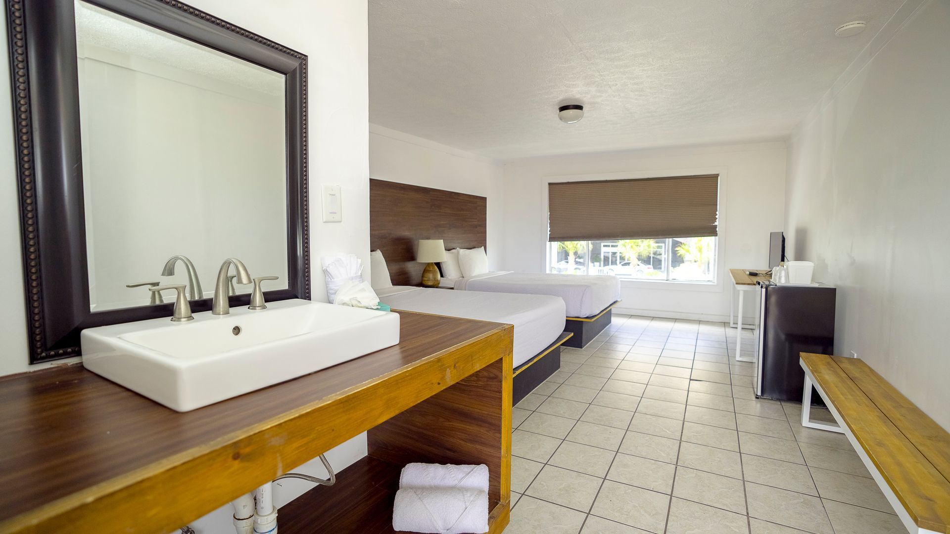 A hotel room with two beds and a sink