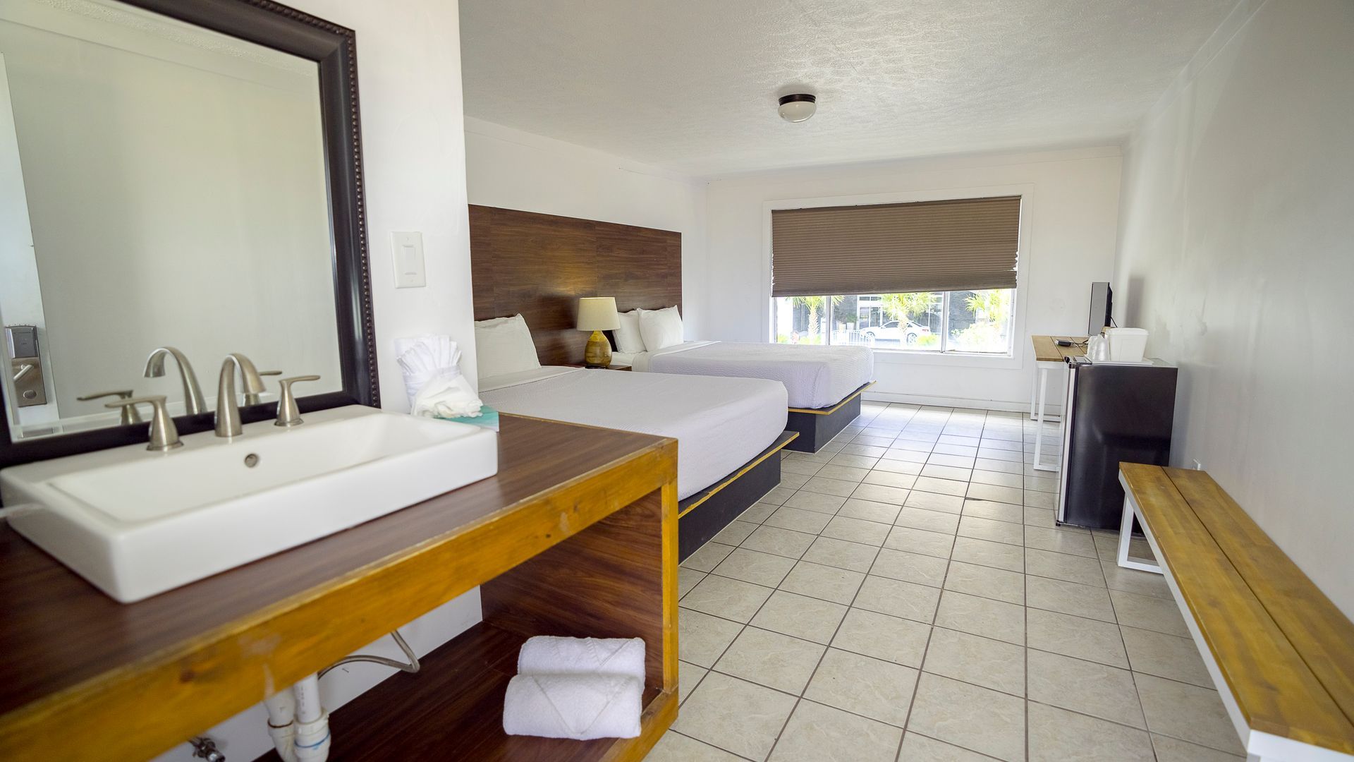 A hotel room with two beds and a sink