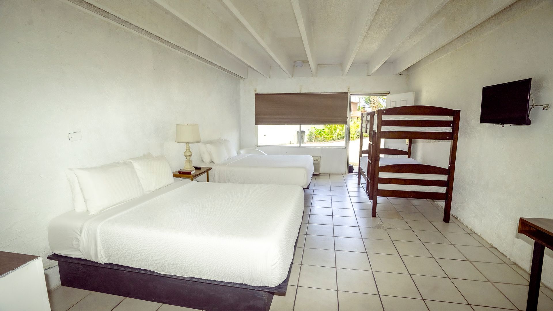 A hotel room with two beds and a bunk bed