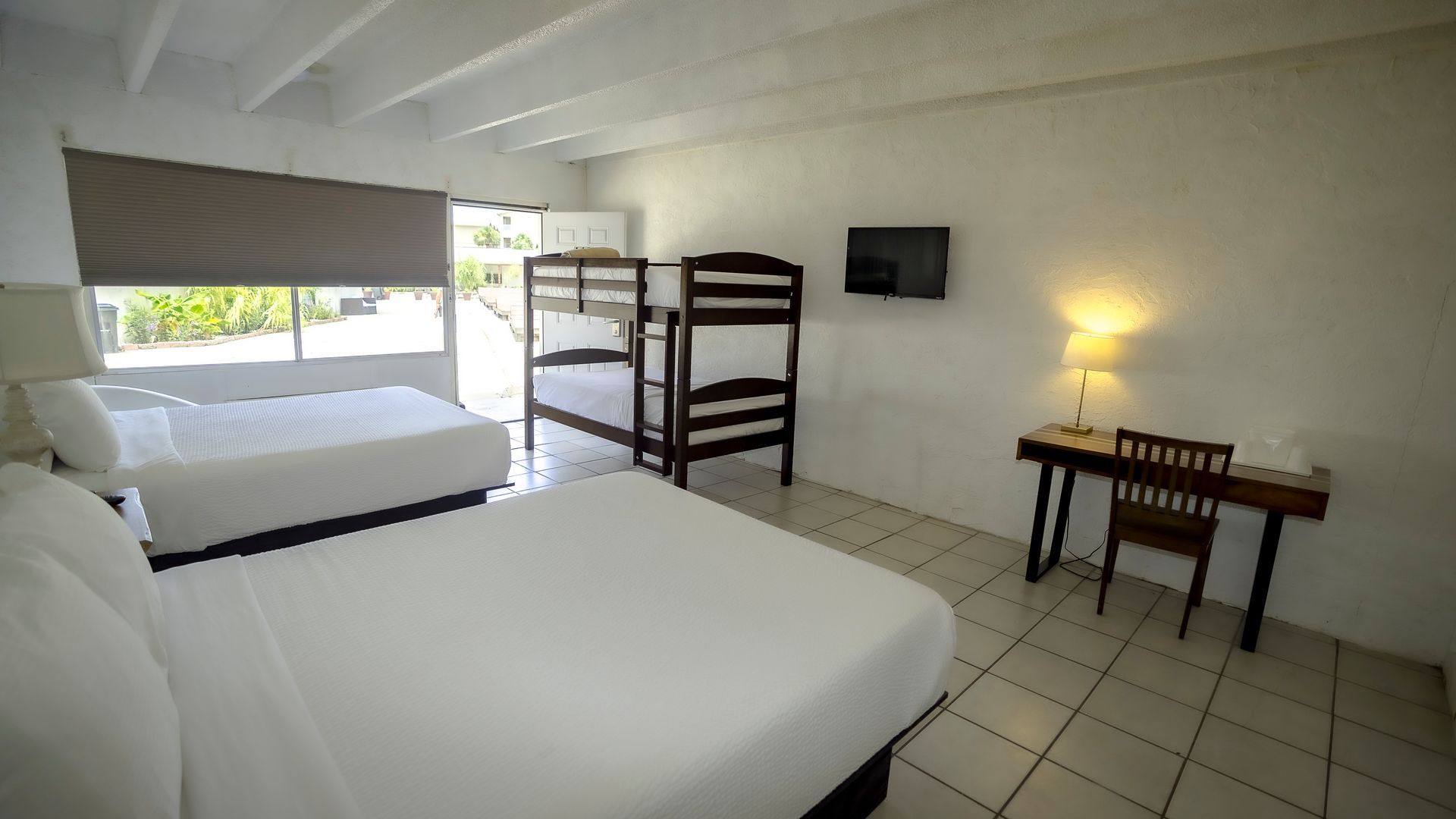 A hotel room with two beds and a bunk bed