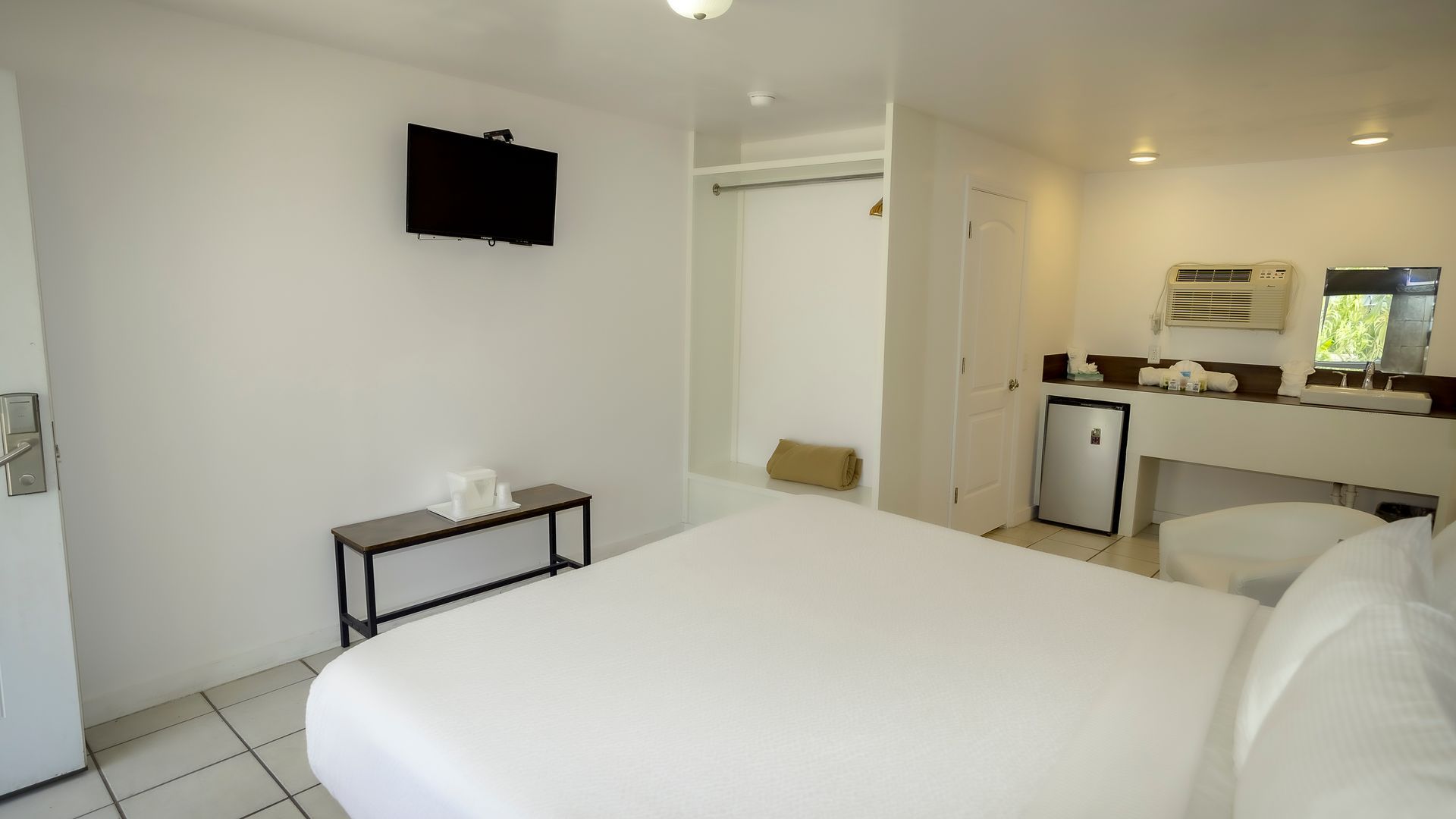 A hotel room with a king size bed and a flat screen tv