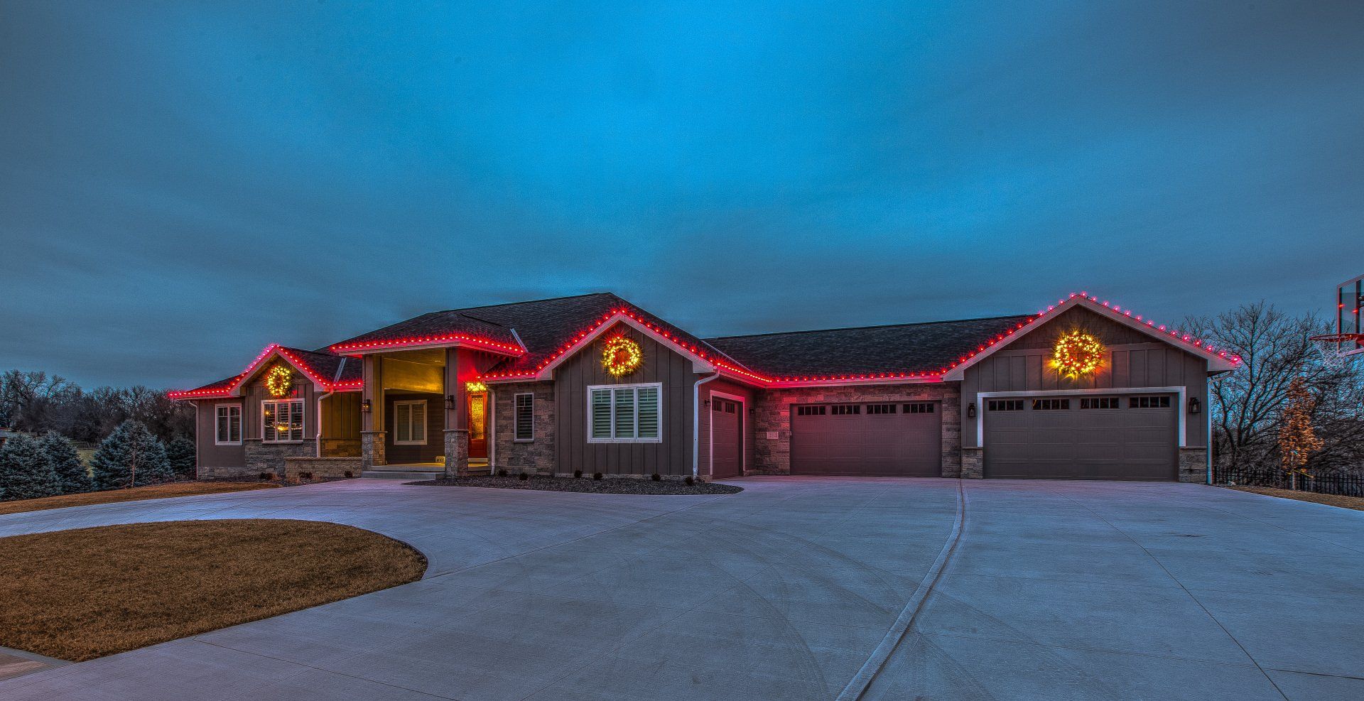 A large house is decorated with christmas lights at night.