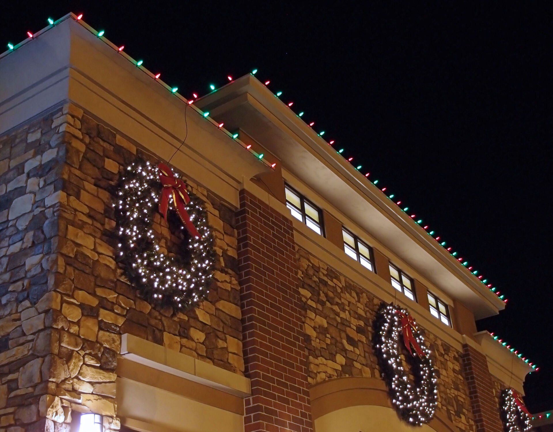 A building with christmas lights and wreaths on it