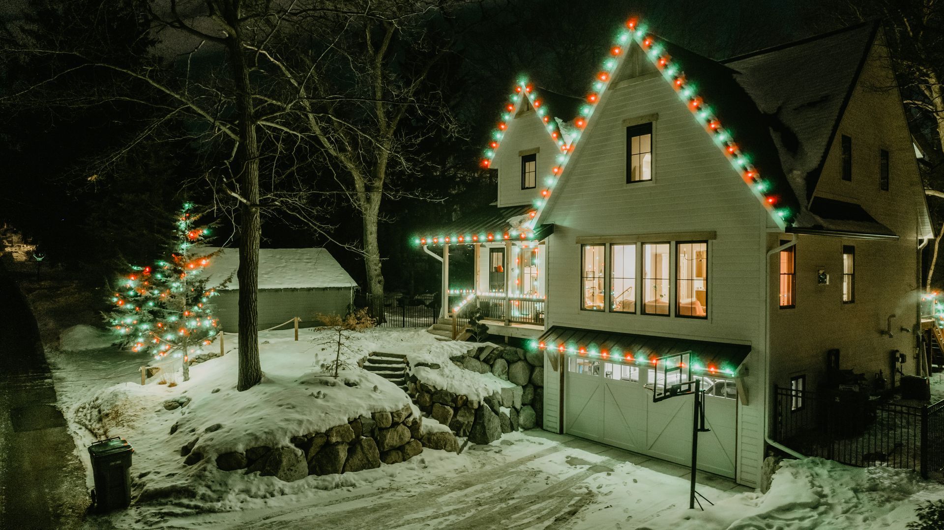 a house decorated with christmas lights is lit up at night