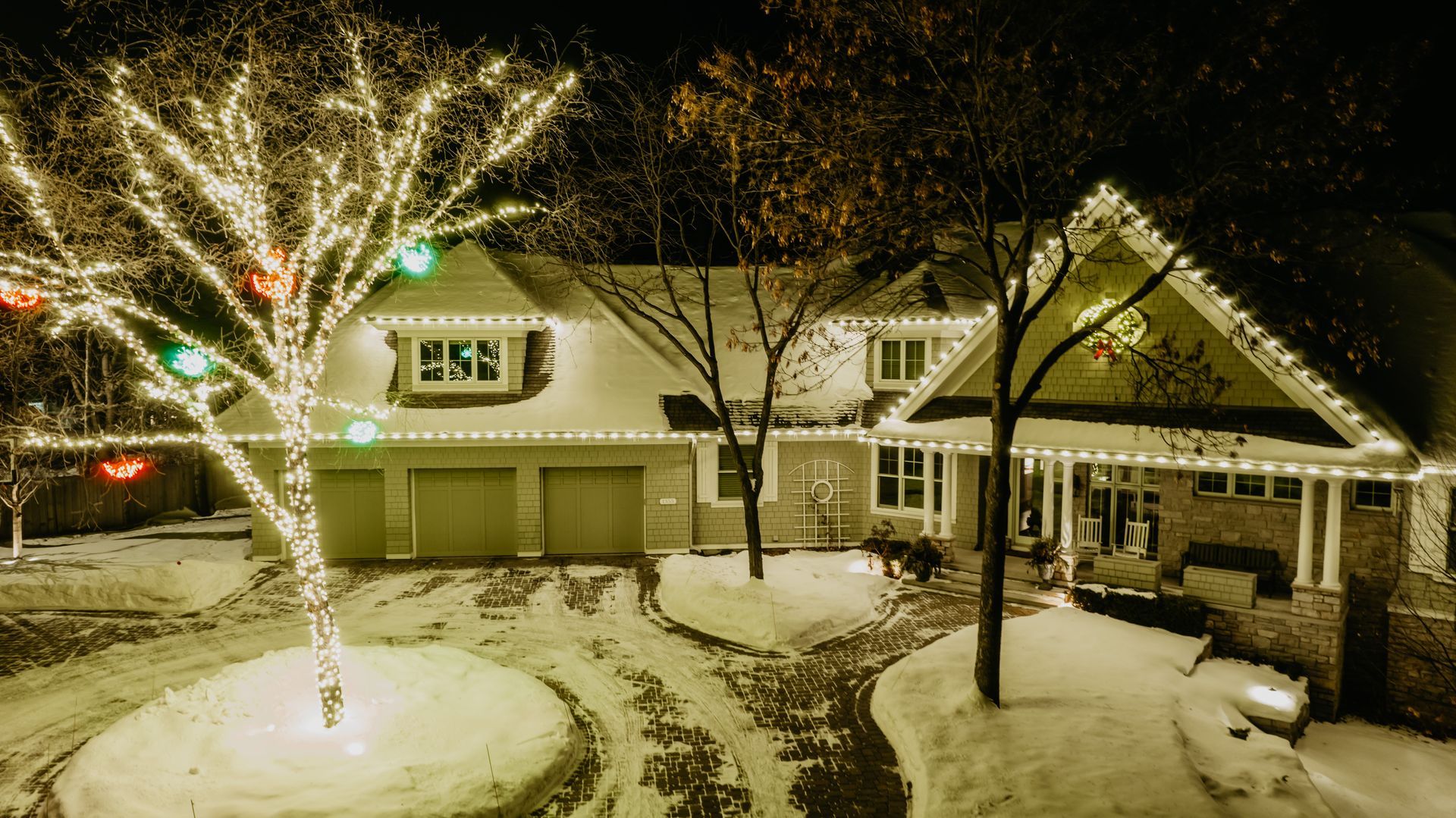 a house decorated with christmas lights and a tree
