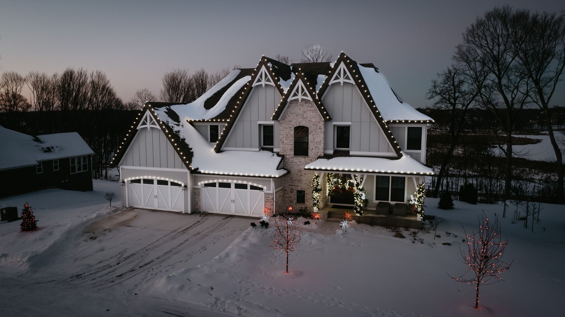 Snow-covered roofline outlined with holiday lights in Maple Grove, MN&rsquo;s Arbor Lakes neighborhood