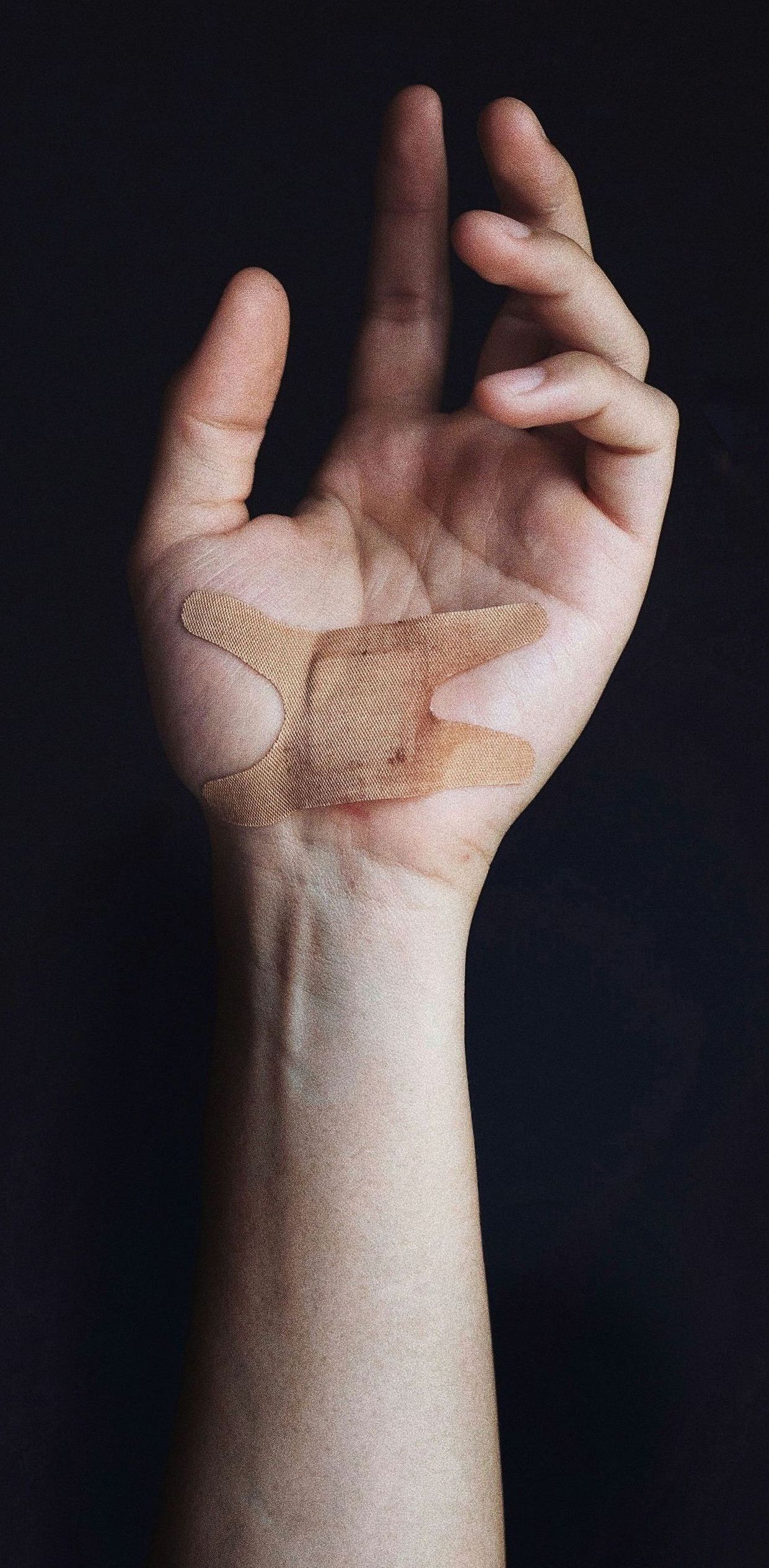 A close up of a person 's hand with a bandaid on it.