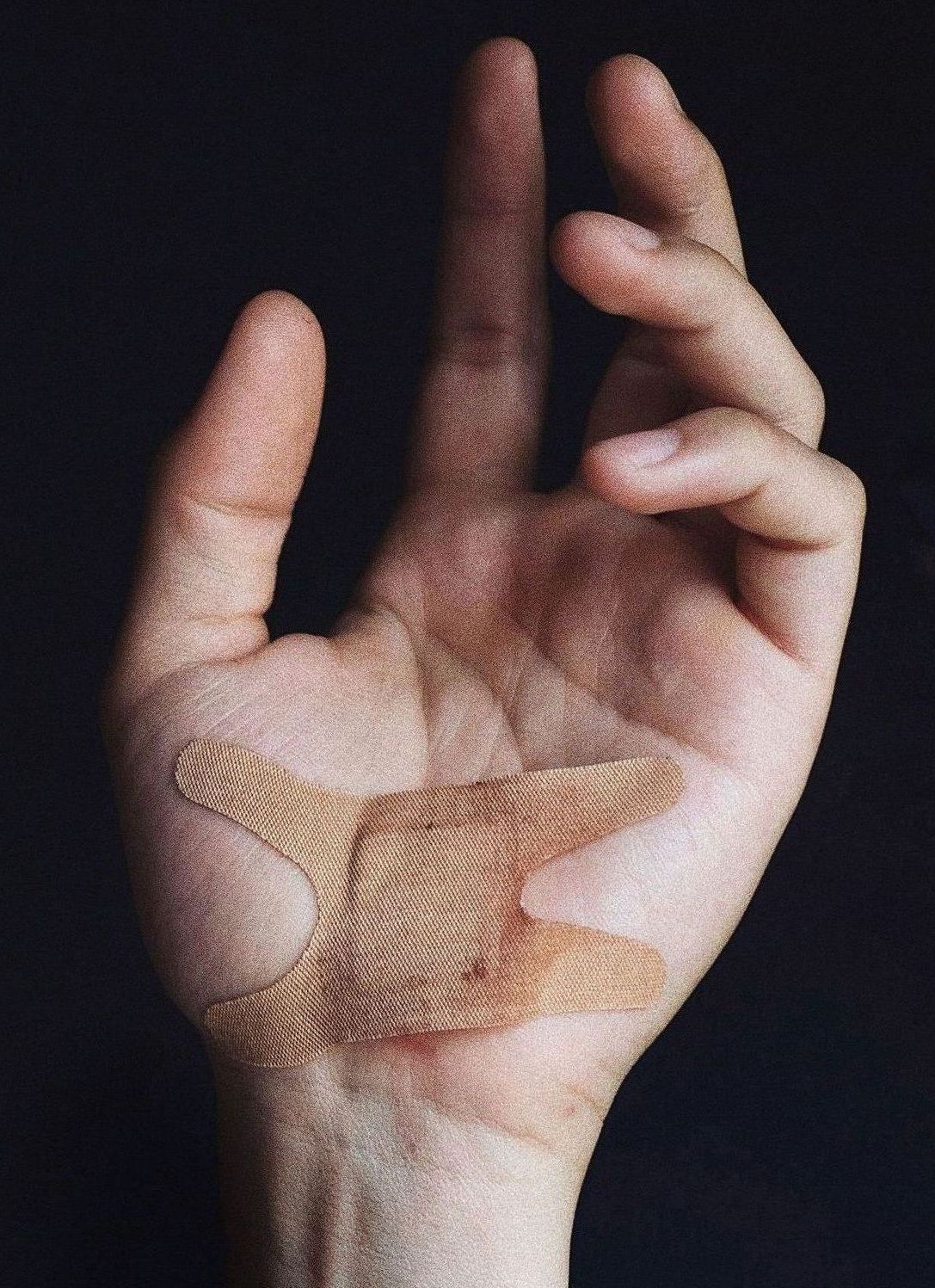 A close up of a person 's hand with a bandaid on it.