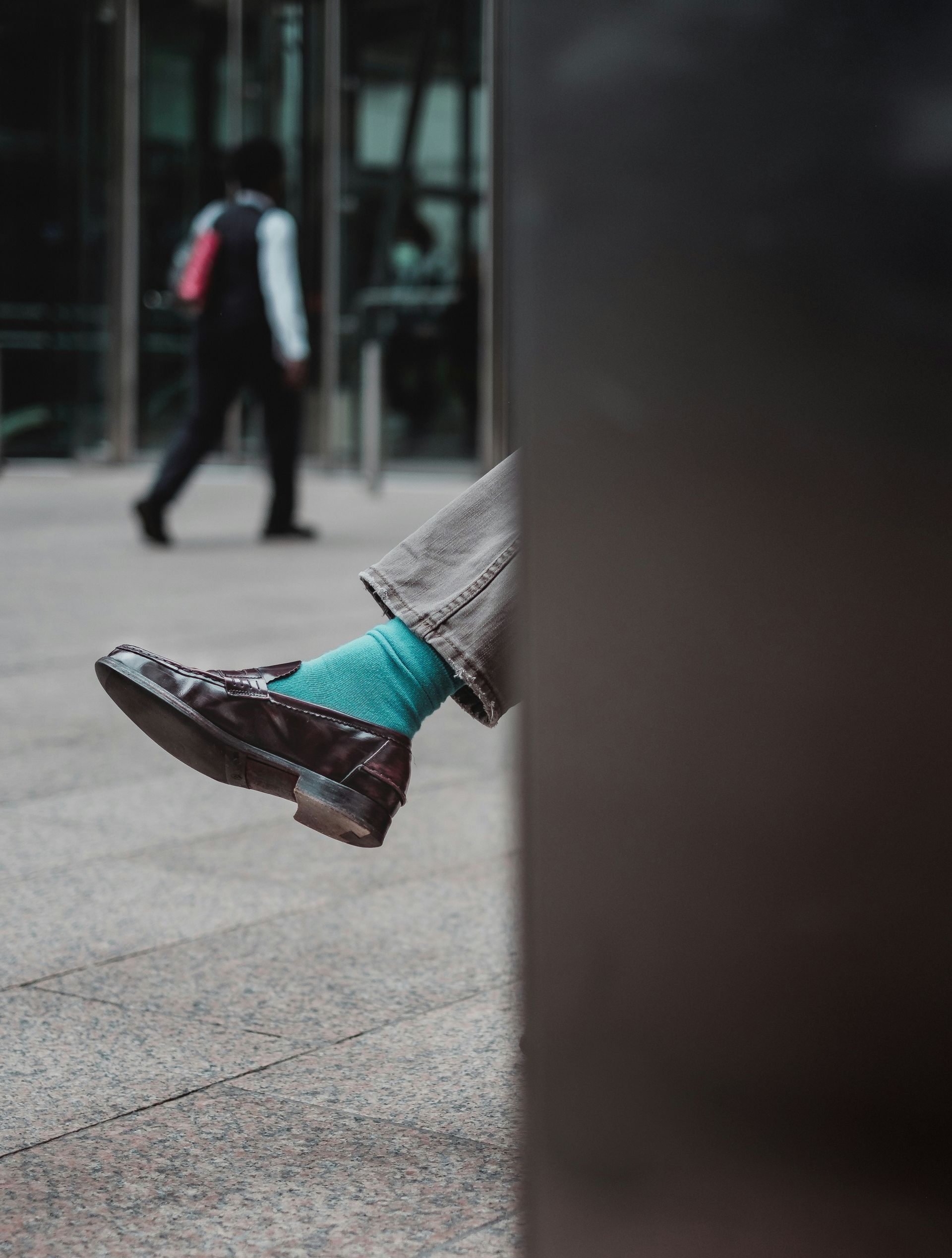 a person wearing green socks and brown shoes is sitting on the ground